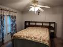 Bright bedroom with double bed, ceiling fan, and built-in shelves at 3376 Se 94Th St, Ocala, FL 34480