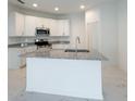 Modern kitchen features white cabinets, stainless steel appliances, and a granite island at 3556 Elliot Pl, Bartow, FL 33830