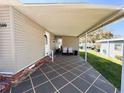 Inviting covered parking area with tiled flooring and space for seating and outdoor enjoyment at 100 Papaya Cv, Leesburg, FL 34748