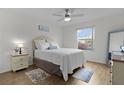 Cozy bedroom featuring a comfortable bed, ceiling fan, and natural light from a large window at 1411 Juarez Pl, The Villages, FL 32159