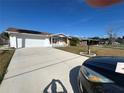 Home exterior featuring a large driveway and attached two-car garage at 1618 Juno Trail, Astor, FL 32102