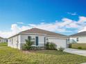 Inviting single-story home with well-kept lawn, complemented by simple landscaping and a convenient two-car garage at 2369 Crossandra St, Mascotte, FL 34753