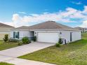 Well-maintained single story home featuring a two-car garage, a neat lawn, and simple landscaping at 2369 Crossandra St, Mascotte, FL 34753