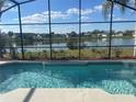 Sparkling pool with a screened enclosure and beautiful lake views beyond at 2410 Shelby Cir, Kissimmee, FL 34743