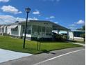 Landscaped manufactured home with a covered carport and street view at 408 Hawthorne Blvd, Leesburg, FL 34748