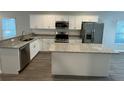 Modern kitchen with stainless steel appliances, granite countertops, and a center island at 412 Avenue M Ne, Winter Haven, FL 33881