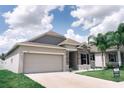 Inviting single-story home featuring a two-car garage, stone accents, and well-maintained landscaping at 414 Taft Dr, Davenport, FL 33837