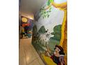 Hallway with incredible custom Disney-themed wall murals and tile floors at 434 Acacia Tree Way, Kissimmee, FL 34758