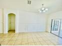 Bright, neutral living room with tile floors, decorative molding, and sliding glass doors leading to the outside at 434 Acacia Tree Way, Kissimmee, FL 34758