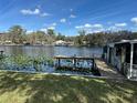Scenic waterfront view featuring a private dock, boat house, and serene water lilies at 55808 Nan Dr, Astor, FL 32102