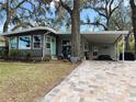 Inviting home with a brick-paved driveway, covered parking, and a cozy, manicured lawn at 106 Royal Palm Dr, Leesburg, FL 34748