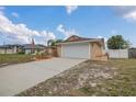 Single-story home with an attached garage, manicured landscaping and a long driveway leading to the house at 1134 Norwood Dr, Deltona, FL 32725