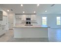 Modern kitchen featuring white cabinets, a center island, stainless steel appliances, and ample counter space at 1212 Caloosa Ridge Ave, Babson Park, FL 33827
