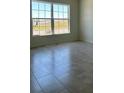 Neutral living room featuring tile floor and abundant light through a double window at 1212 Caloosa Ridge Ave, Babson Park, FL 33827