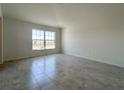 Spacious living room with neutral walls, modern tile floors, and a bright, sunny window at 1212 Caloosa Ridge Ave, Babson Park, FL 33827