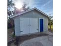 The detached garage has a white double door and a blue side entrance at 134 Daytona Ave, Daytona Beach, FL 32117