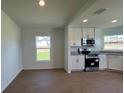 Modern kitchen with white cabinetry, stainless steel appliances, granite countertops, and wood-look tile at 141 W 6Th St, Frostproof, FL 33843