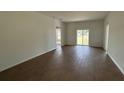 Spacious living room with wood-look tile flooring and a sliding glass door that fills the area with light at 141 W 6Th St, Frostproof, FL 33843