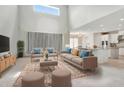 This bright, furnished living room features high ceilings, neutral carpet and decor and an open-concept design at 1447 Myrtle Oaks Trl, Oviedo, FL 32765