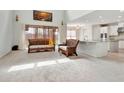 Bright living room boasts wicker furniture, neutral carpet, and large windows with light pouring in at 1447 Myrtle Oaks Trl, Oviedo, FL 32765