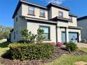 Two-story home with manicured landscaping, including green bushes and pink flowers at 207 Aidans Lndg, Haines City, FL 33844