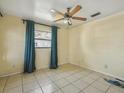 Bright bedroom with tile flooring, ceiling fan, and natural light from the window at 2403 Nansen Ave, Orlando, FL 32817