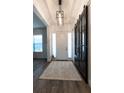 Bright entryway features modern light fixture, wood flooring, and attractive sliding barn door at 25879 Crossings Bluff Ln, Sorrento, FL 32776
