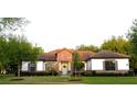 Charming single-story home featuring a tile roof, stone accents, manicured lawn and mature landscaping at 25879 Crossings Bluff Ln, Sorrento, FL 32776
