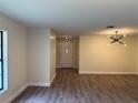 Sunlit living room featuring wood-look flooring, white walls, and modern lighting fixtures at 303 E Fountain St, Fruitland Park, FL 34731