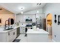 Bright kitchen with modern appliances, white cabinets, and island, offering a clean, updated space at 402 Bramble Way, Minneola, FL 34715