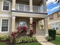 Inviting two-story home featuring a cozy front porch and balcony with decorative landscaping at 7117 Red Lantern Dr # 7117, Harmony, FL 34773
