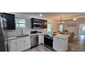 Stylish kitchen with stainless appliances, island cooktop, and open layout to the living area at 906 Se 3Rd St, Mulberry, FL 33860