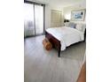 Cozy bedroom with a comfortable bed, light wood floors, and natural light from the big window at 1 Oceans West Blvd # 3B4, Daytona Beach, FL 32118