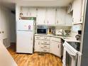 Functional kitchen featuring white cabinetry, laminate countertops, and modern appliances at 114 Caladium St, Leesburg, FL 34748