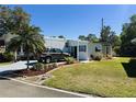 Cozy home with manicured lawn and garden, covered entrance, and ample parking on a sunny day at 123 Pyracantha Ln, Leesburg, FL 34748