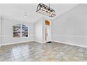 Bright living room featuring tile floors, arched window, and modern light fixture at 1333 Darnaby Way, Orlando, FL 32824
