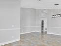 Spacious living area with decorative chair railing, tile flooring, and modern light fixture at 1333 Darnaby Way, Orlando, FL 32824