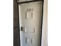 Front door with number 205 and decorative white frames at 1640 Juno Trl # 205B, Astor, FL 32102