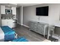 Bedroom featuring two beds, a small refrigerator, cabinets, desk, and a television at 1909 S Atlantic Ave # 703, Daytona Beach, FL 32118