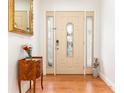 Inviting foyer with hardwood floors and a decorative wooden front door with glass panels at 1928 South Blvd, Maitland, FL 32751