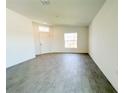 Bright living room featuring wood-look tile floors, a large window, and a white front door at 2117 Lincoln Ln, Bartow, FL 33830