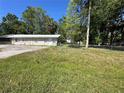 Fenced backyard with lush green grass and a view of the property at 24047 Ermine Rd, Astor, FL 32102