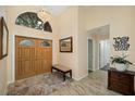 The foyer features double wood doors, a decorative chandelier, a mirror, and tile flooring at 365 N Spaulding Cv, Lake Mary, FL 32746