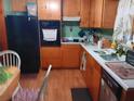 Functional kitchen featuring wood cabinets, black appliances, and a practical layout at 6832 Oswego Dr, Mount Dora, FL 32757
