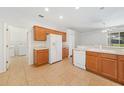 Bright eat-in kitchen features white appliances, wooden cabinets, and tile flooring at 9651 Old Marsh Ct, Orlando, FL 32832