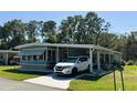 Inviting single-story home showcasing a carport, lush green lawn, and a well-kept exterior at 121 Bougainvillea Dr, Leesburg, FL 34748