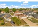 Aerial view of the home, highlighting the driveway, garage, and landscaped front yard in a residential neighborhood at 144 Pinewood Cir, Kissimmee, FL 34743