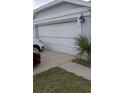 Damaged white garage door of a single-Gathering home with cars parked in the driveway at 1484 Avleigh Se Cir, Orlando, FL 32824