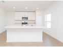 Bright kitchen featuring an island, modern white cabinets, and stainless steel appliances at 2173 Lincoln Ln, Bartow, FL 33830
