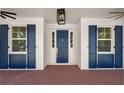 Elegant entryway showcasing a stylish door with sidelights, decorative shutters, and brick flooring at 2561 Rogers Rd, Lakeland, FL 33812